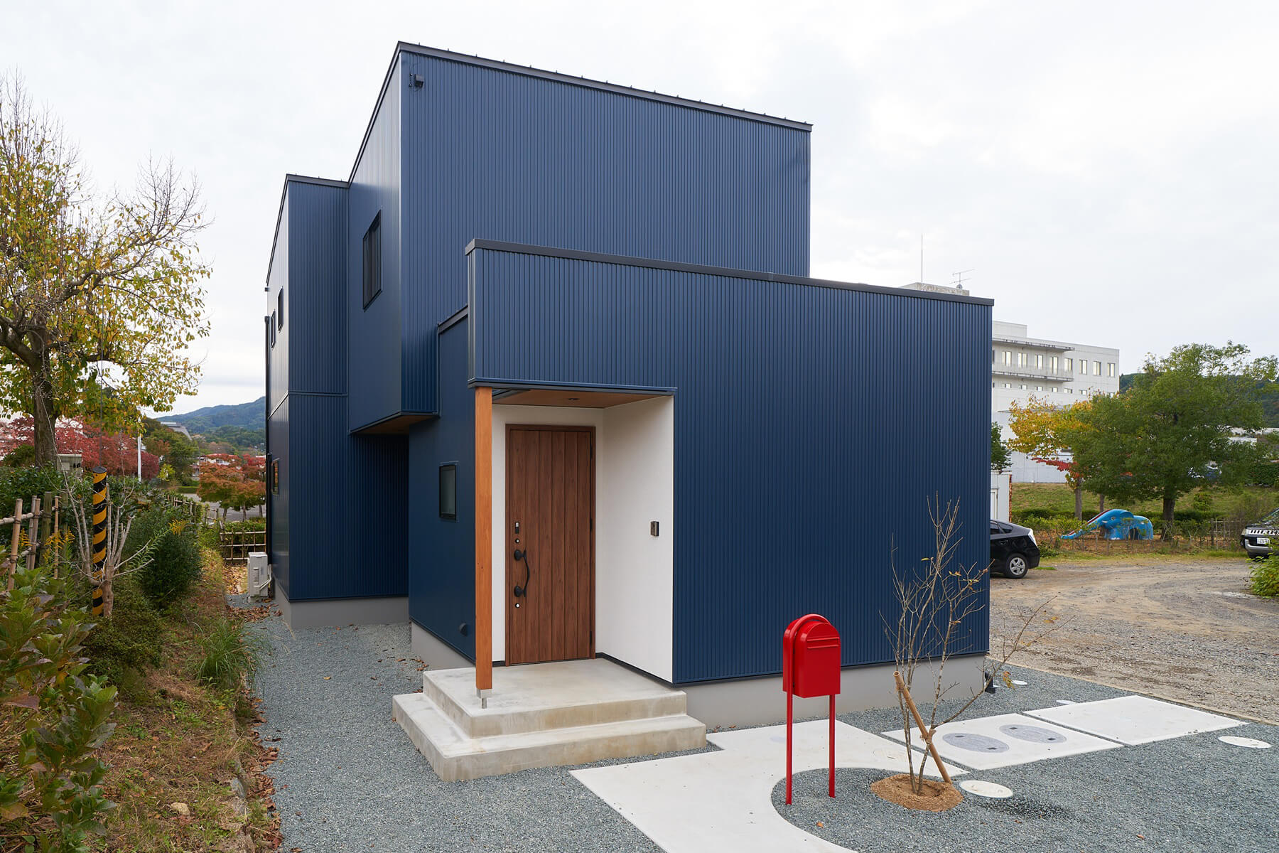 窓がないファサードがご家族のプライバシーを守り、建物の形状と素材感を際立たせる。